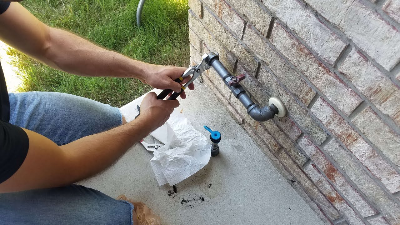Technician installing outdoor gas line on a brick wall